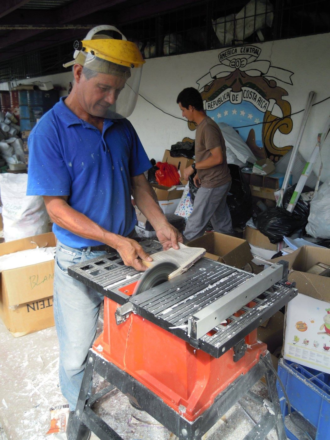 Trabajo en el centro de reciclaje de mi destino; el escudo de Costa Rica en la pared