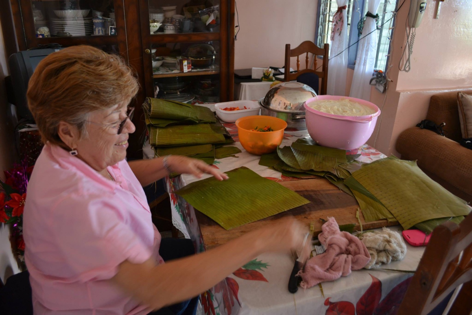 Una abuela acomodando hojas de plátano