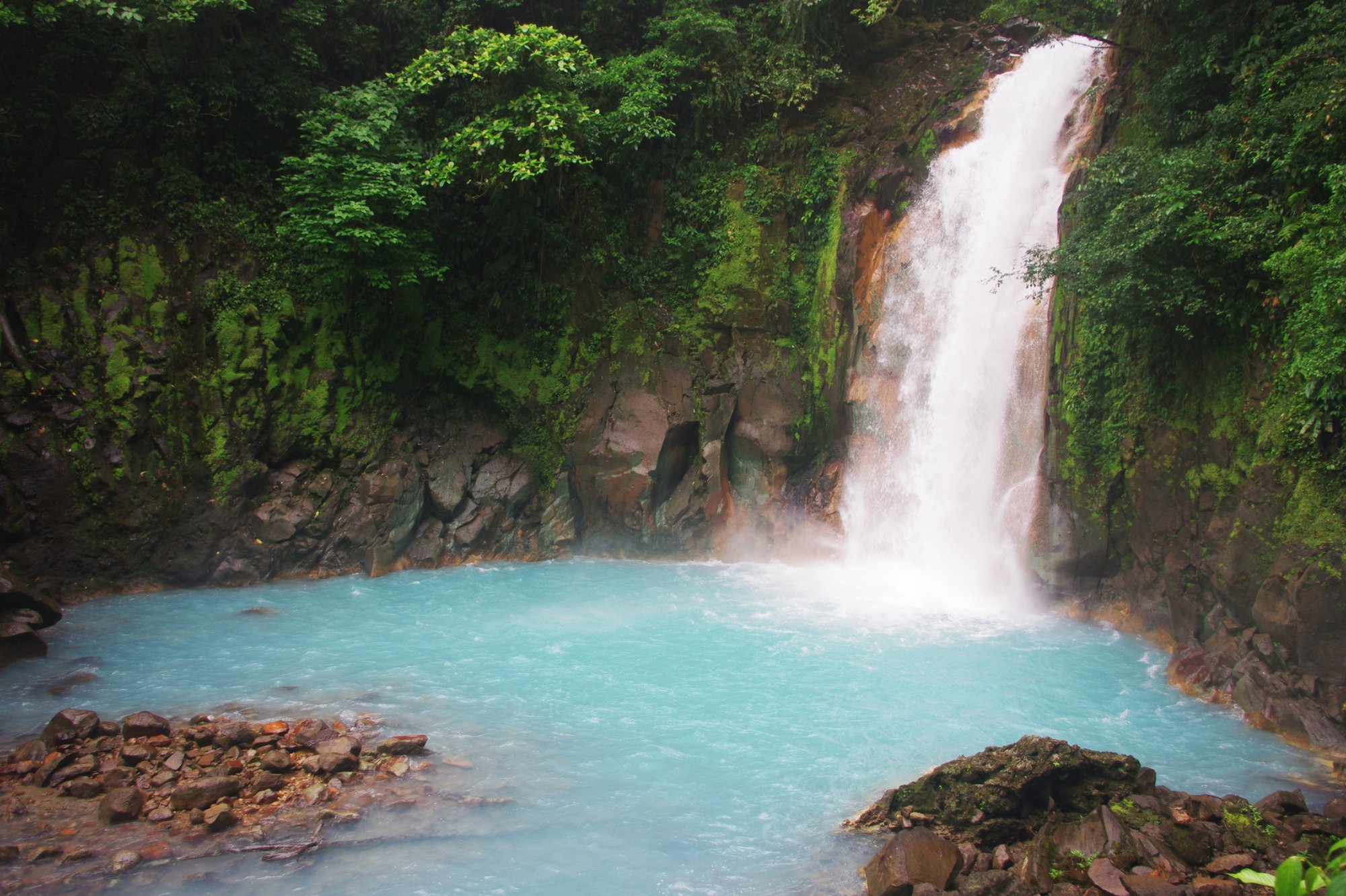 The Río Celeste waterfall, white water falling into a milky-blue pool