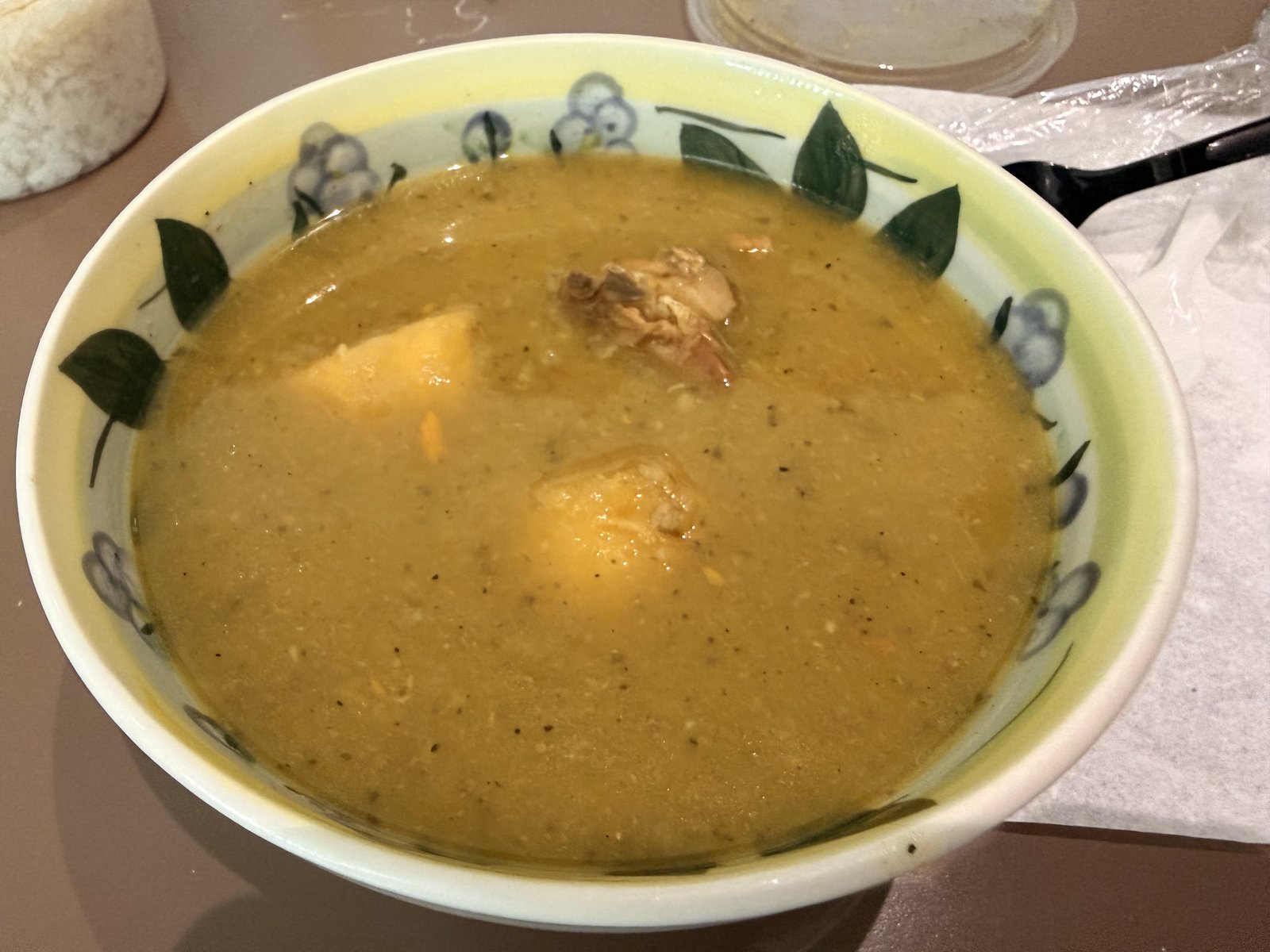 A bowl of sancocho: golden, thick stew with chicken and root vegetables