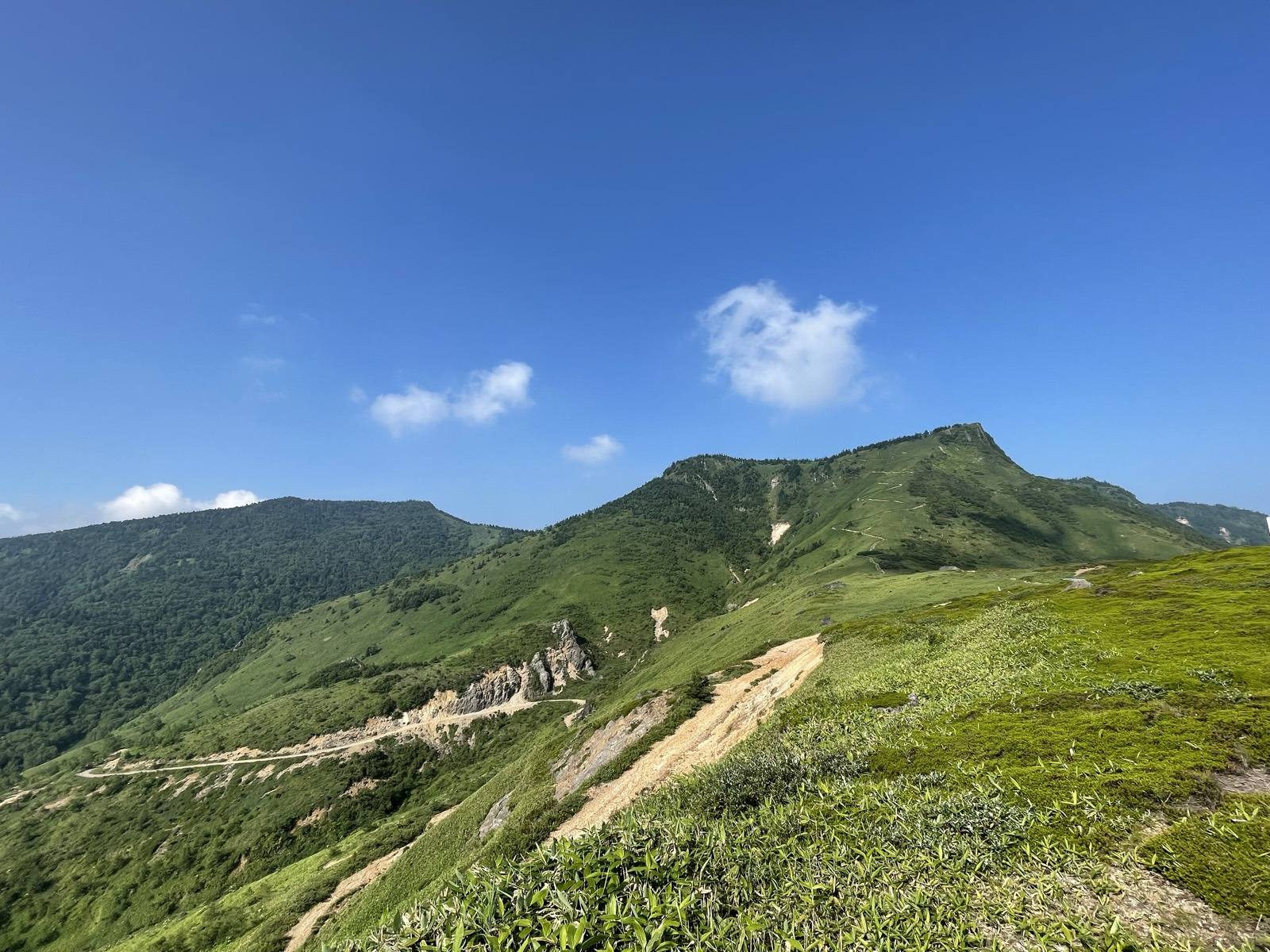 The green ridgeline of Kenashi Pass and a road threading the valley